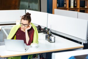 cold office worker wearing blanket