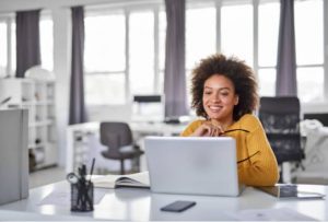 out of office message - woman at her desk on a computer