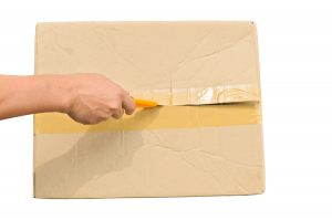 carefully opening a box containing a desk