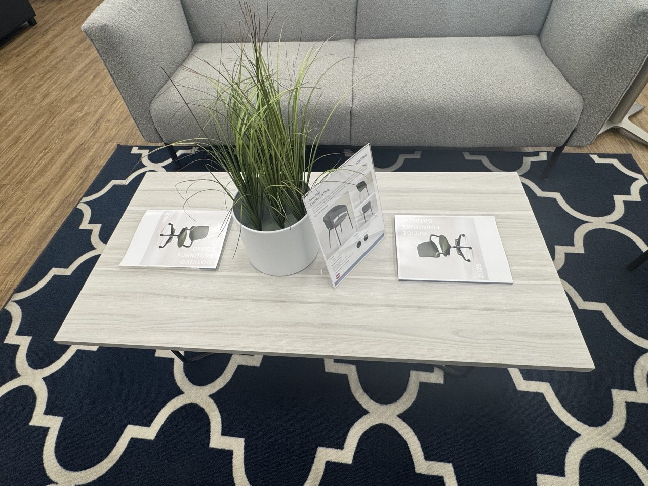 Modern rectangular coffee table with rod metal base in a collaborative office lounge at the Office Furniture EZ showroom in Denver, Colorado.