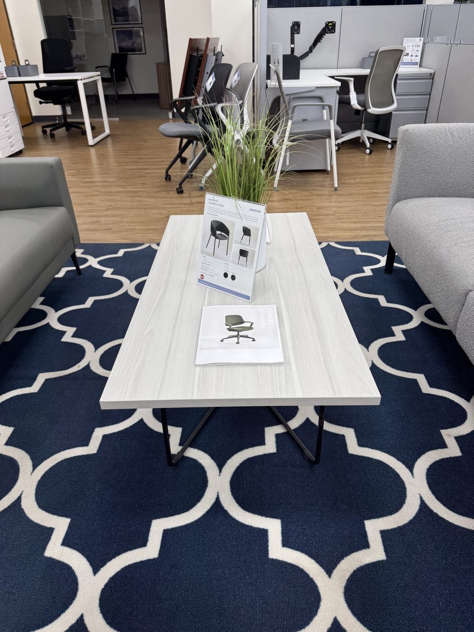 Modern rectangular coffee table with rod metal base in an office reception lounge at the Office Furniture EZ showroom in Denver, Colorado.