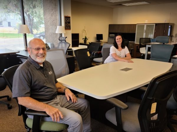 ounder Gary Schwankl sitting at a conference table in the Office Furniture EZ showroom with a client