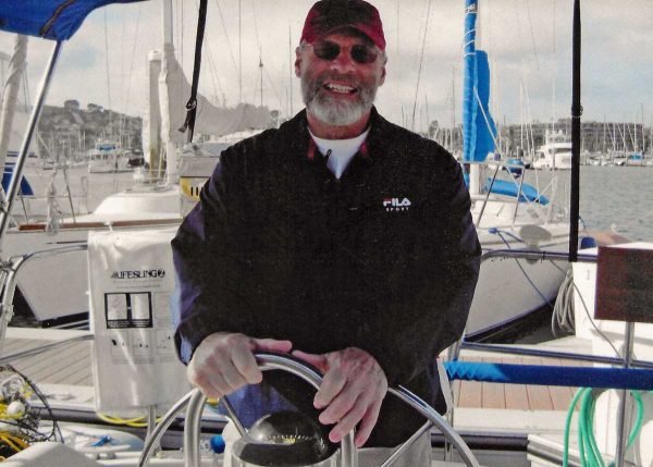 Office Furniture EZ founder Gary Schwankl steering a sailboat in San Diego California.