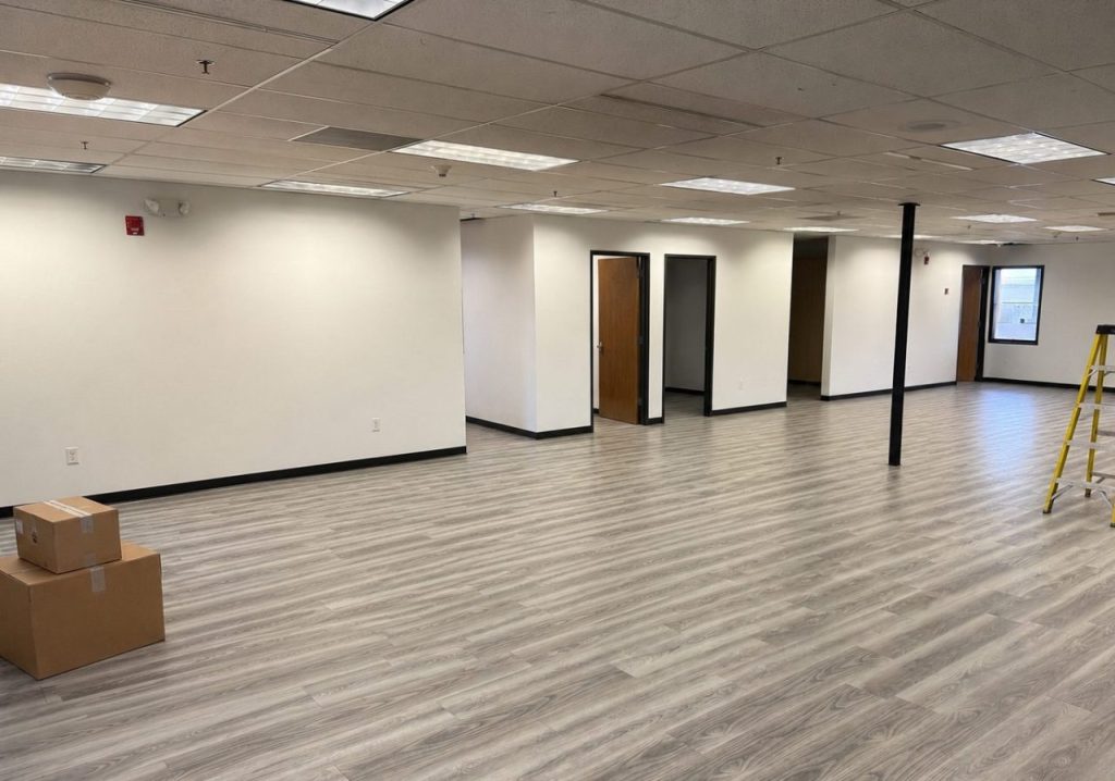 An empty commercial office space with tools and a ladder ready for a furniture installation project in Denver.