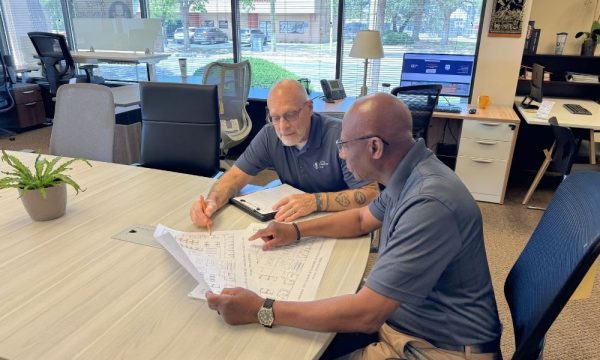 Two men consulting about an office furniture project at Office Furniture EZ's showroom