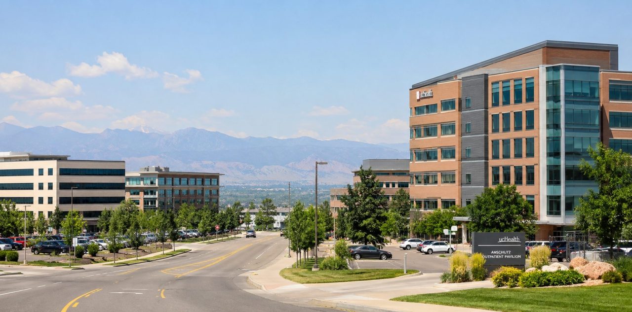Office and medical buildings in Aurora, Colorado, with landscaped streets and the Front Range in the distance.