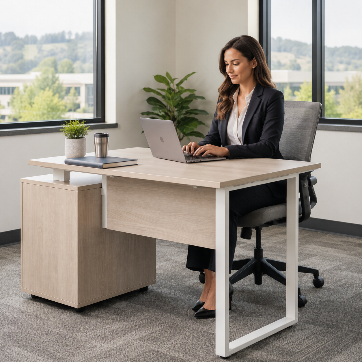 A woman working in an office setting. She's seated at a modern sit-stand desk.