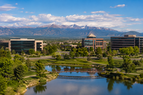 Scenic view of Centennial, Colorado with landscaped office park, pond, walking paths, and mountain backdrop
