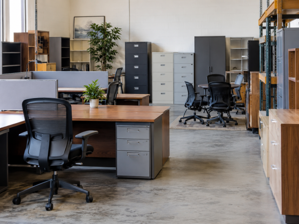 Used office desks, chairs, filing cabinets and storage in a warehouse setting