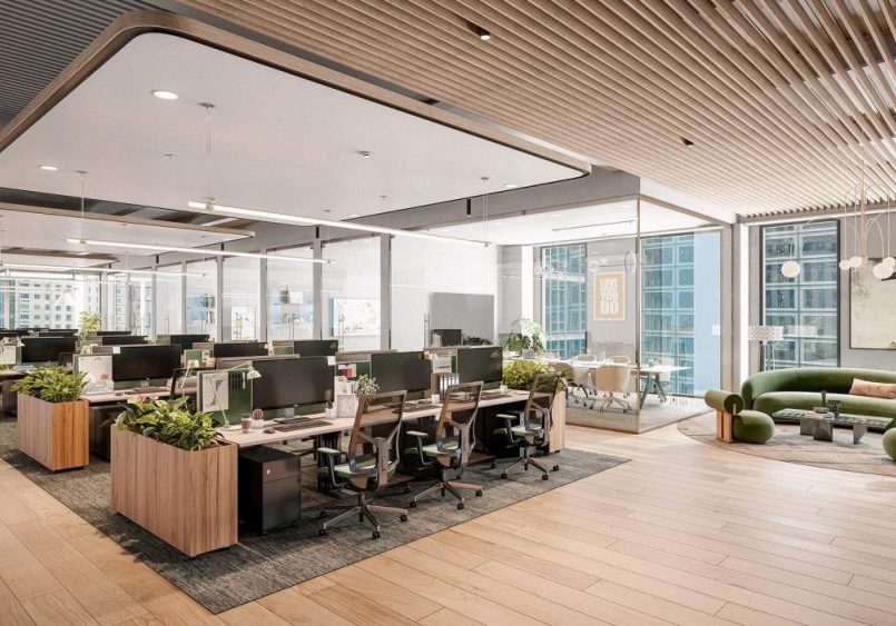 A coworking space with a variety of seating options including bench style desking, lounge, and stand up desks.